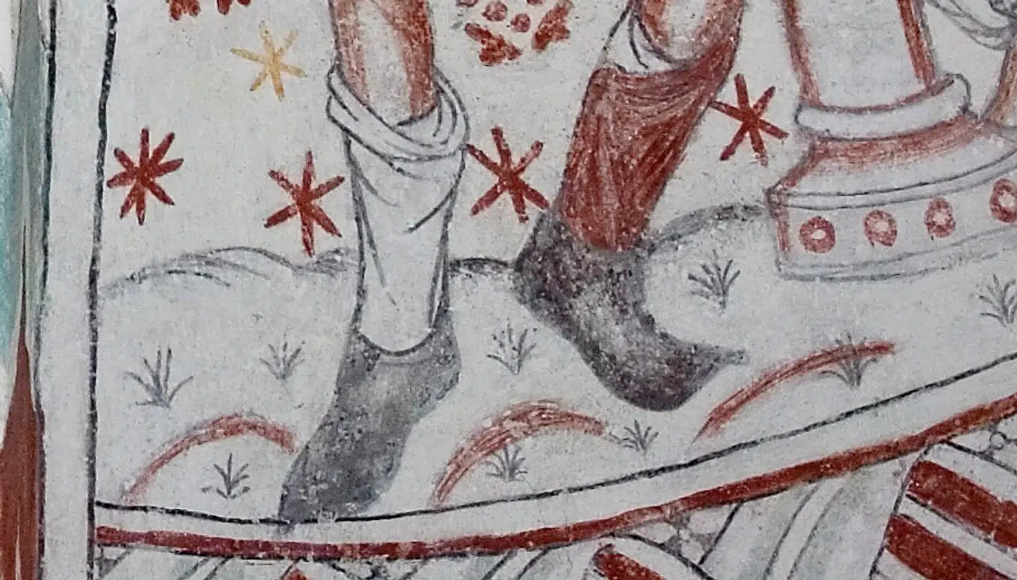 Her ses et par spidse sko på et kalkmaleri i en dansk kirke.