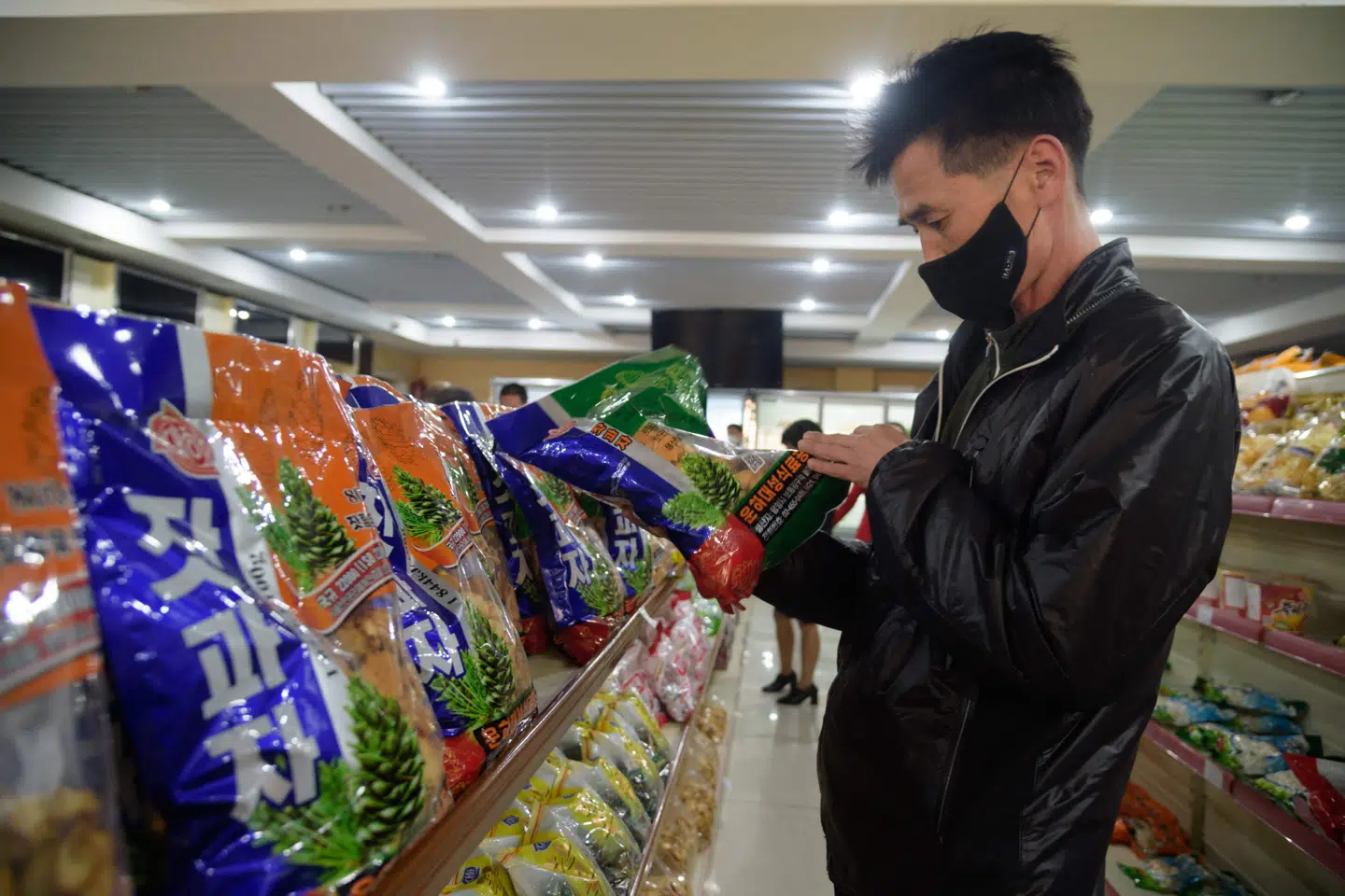 En mand ser på snack af det nordkoreanske brand Taeha i en butik i Pyongyang. Nordkorea har for nylig indført en radikal ny lovgivning, som har til formål at forhindre enhver form for udenlandsk indflydelse. Det rapporterer BBC. Kim Won Jin/Ritzau Scanpix