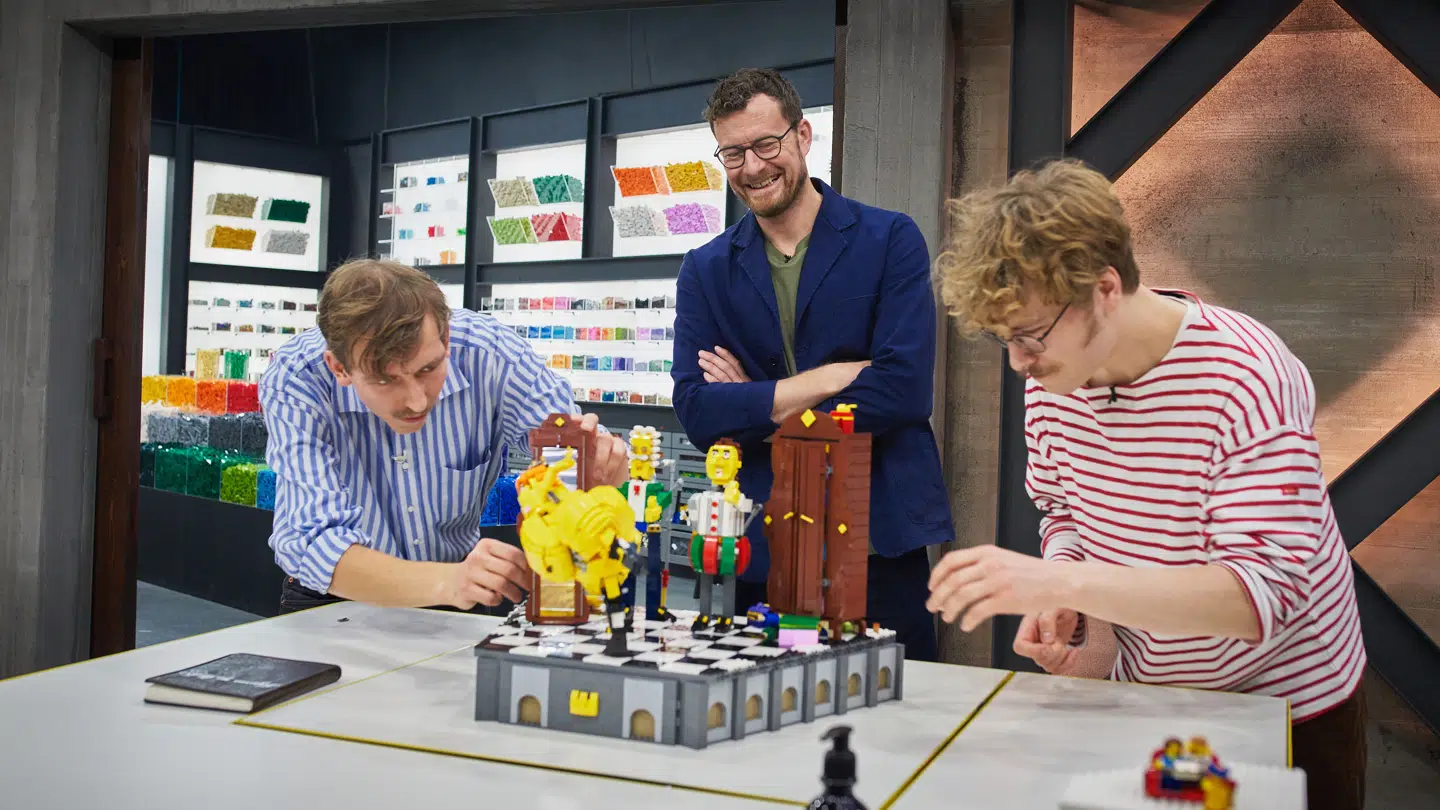'Lego Masters'-dommeren Søren Dyrhøj vurderer i andet program Frederik Randbøll Jørgensen og Magnus Klint Sørensens foreløbige byg. I baggrunden kan man se det lille klodskammer, som man også ser i programmet, men som altså gemmer på et enormt baglokale med ti gange så mange legoklodser.