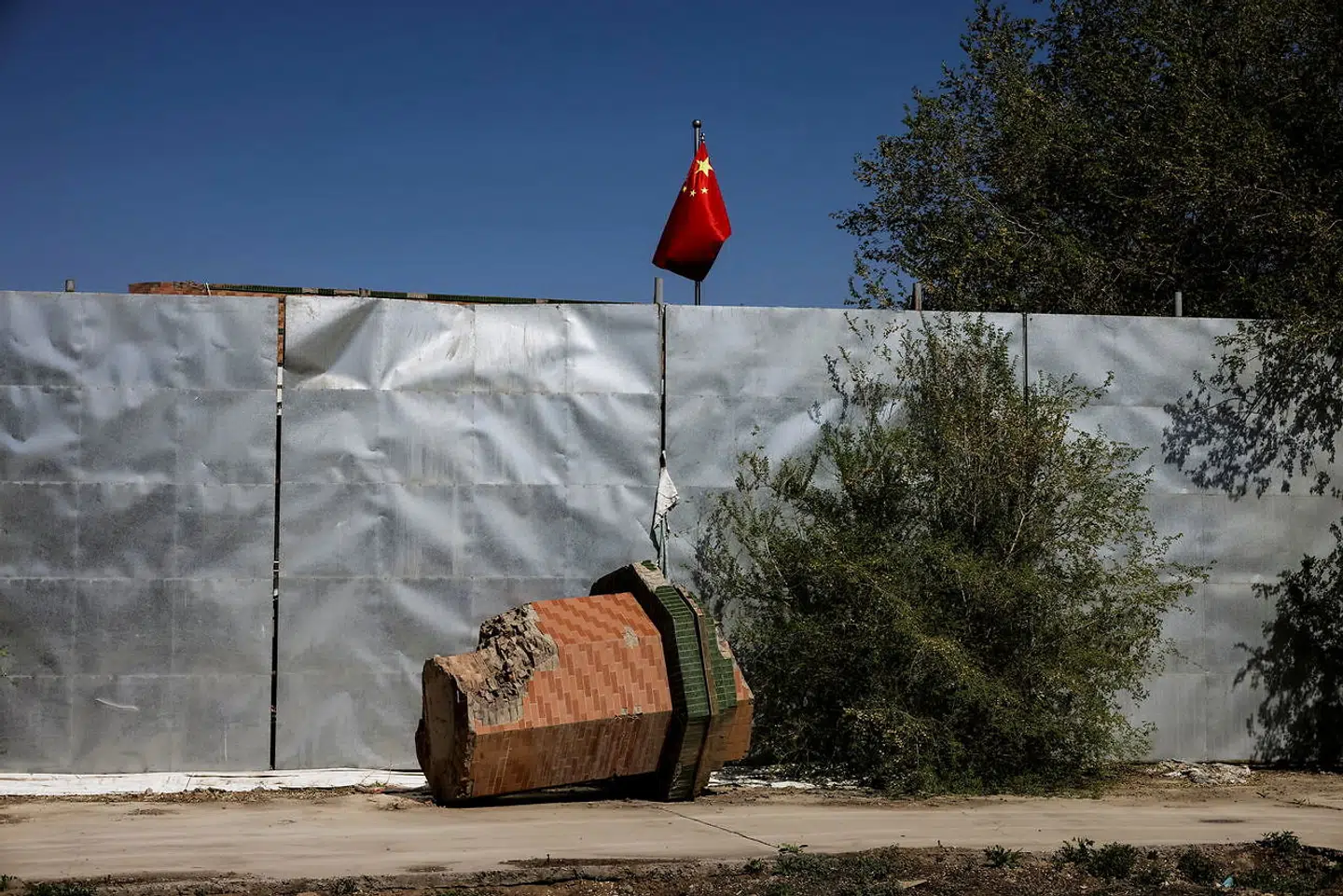 Her ligger en del af minareten, der før var en del af moskeen. Det kinesiske flag vejer i baggrunden.