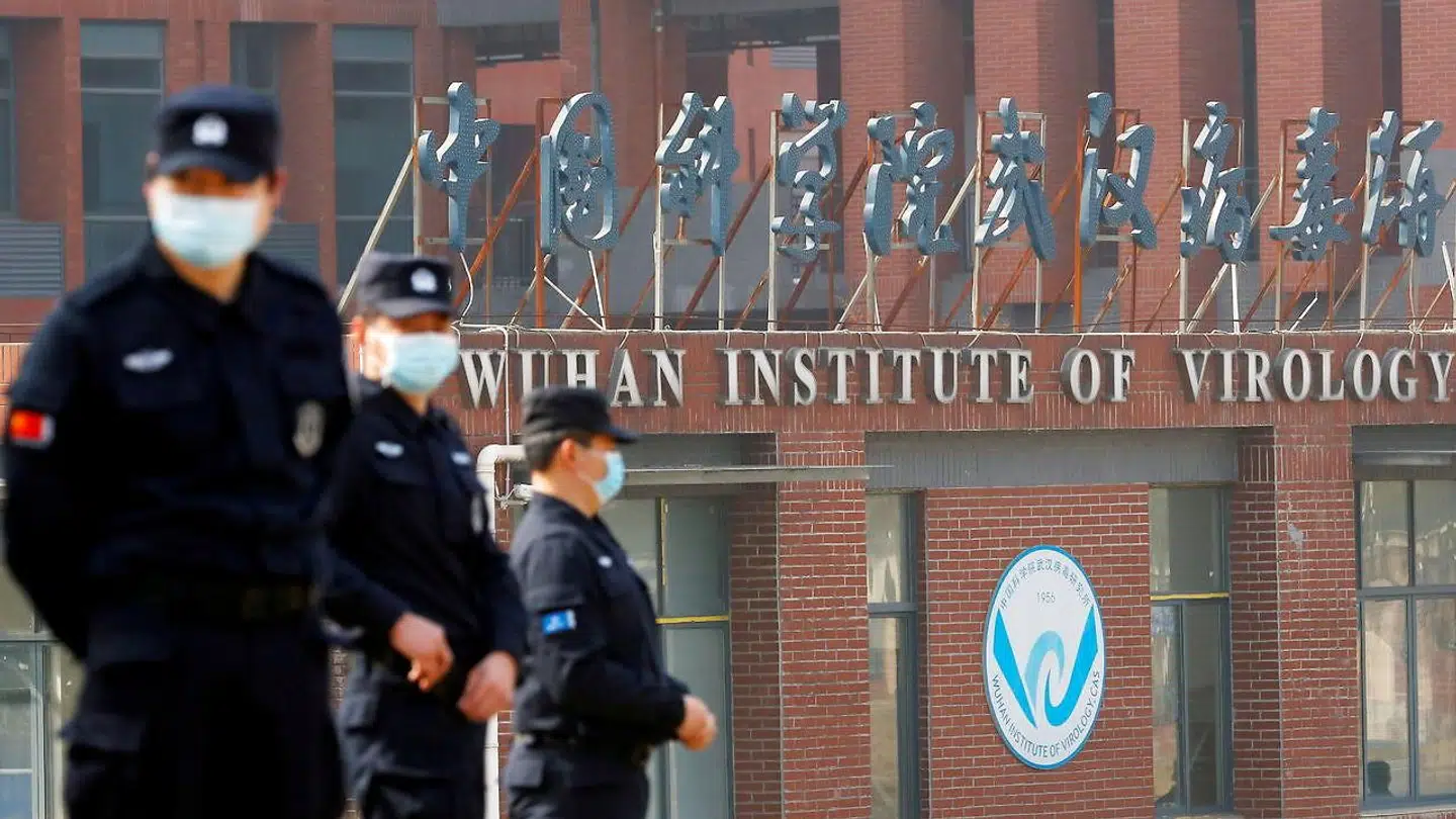 Sikkerhedsvagter foran Wuhan Institute of Virology, mens et hold forskere fra WHO inspicerer bygningen i februar 2021.