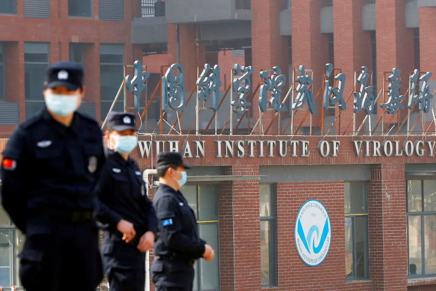 Sikkerhedsvagter foran Wuhan Institute of Virology, mens et hold forskere fra WHO inspicerer bygningen i februar 2021.