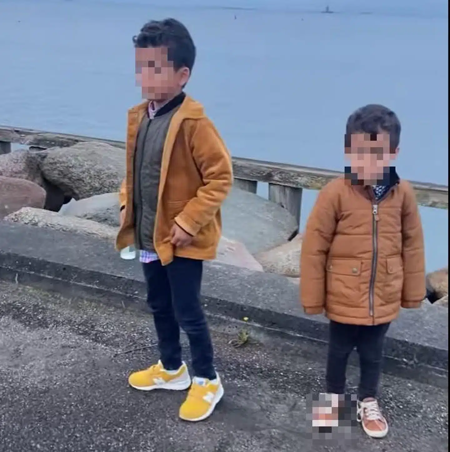 Seksårige Iyad og treårige Malek så på, mens deres forældre diskuterede med den fremmede mand på havnen.