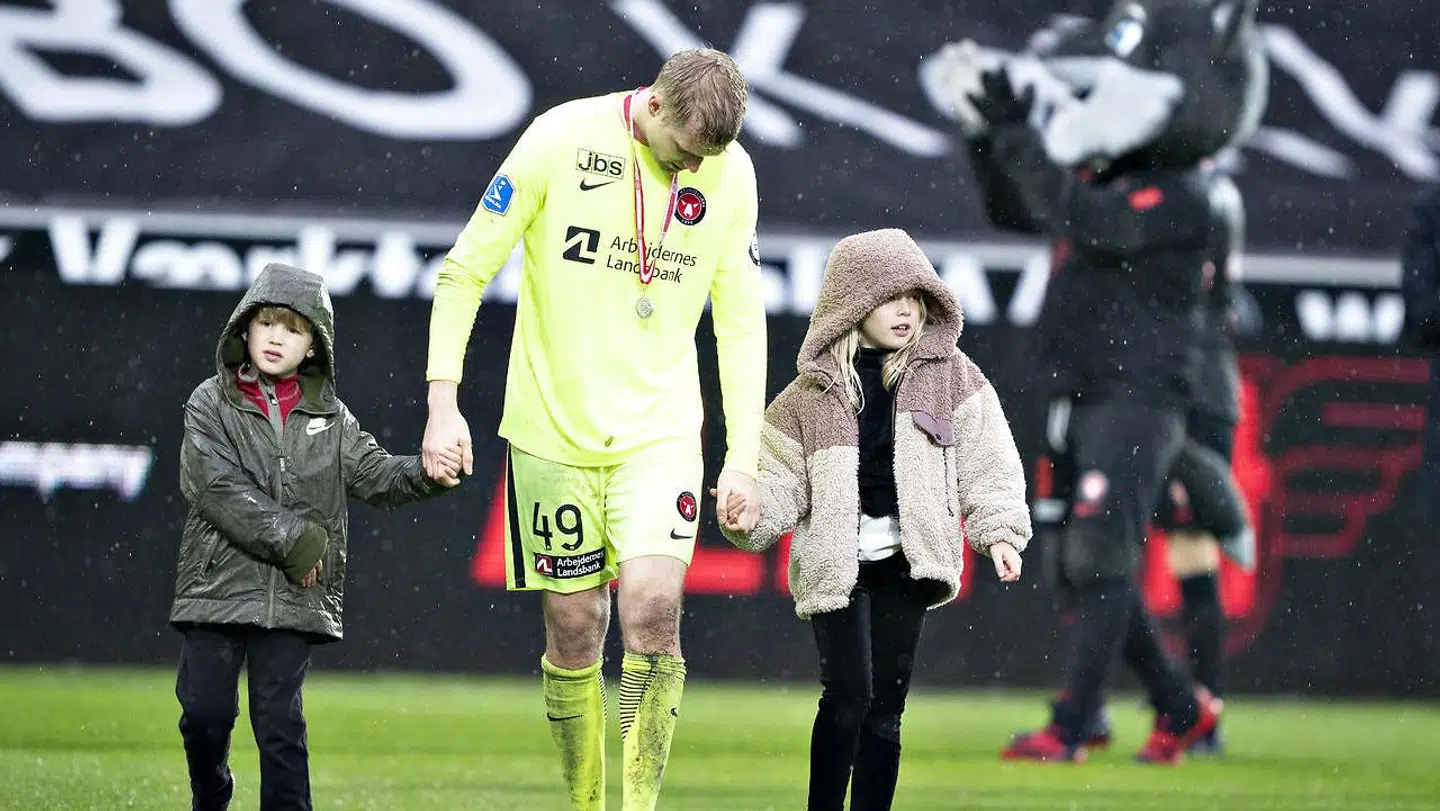 En skuffet Jonas Lössl med sølvmedaljen om halsen og sine børn i hånden efter dagens kamp.