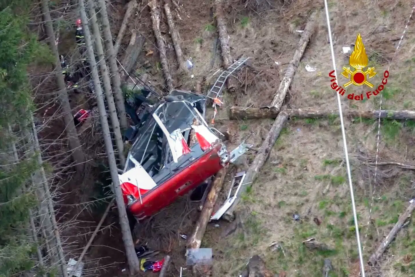 A photo grabbed from an aerial video taken on May 23, 2021 and handout on May 24, 2021 by The Italian Firefighters "Vigili del Fuoco" shows rescuers at work by a cable car that crashed to the ground in the resort town of Stresa on the shores of Lake Maggiore in the Piedmont region. - 14 people died on May 23 after a cable car crashed to the ground in northern Italy, emergency services said. (Photo by Handout / Vigili del Fuoco / AFP) / RESTRICTED TO EDITORIAL USE - MANDATORY CREDIT "AFP PHOTO / VIGILI DEL FUOCO / HANDOUT " - NO MARKETING - NO ADVERTISING CAMPAIGNS - DISTRIBUTED AS A SERVICE TO CLIENTS