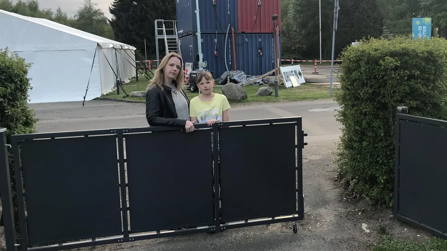 Maja og hendes datter i deres indkørsel, taget fra haven ved den låge, de har sat op.
