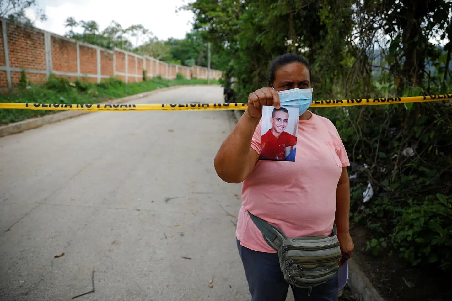 Denne kvinde, Marleny Barrientos, viser et billede af sin søn, som forsvandt for seks år siden. Nu frygter hun, at han ligger begravet sammen med de andre ofre.