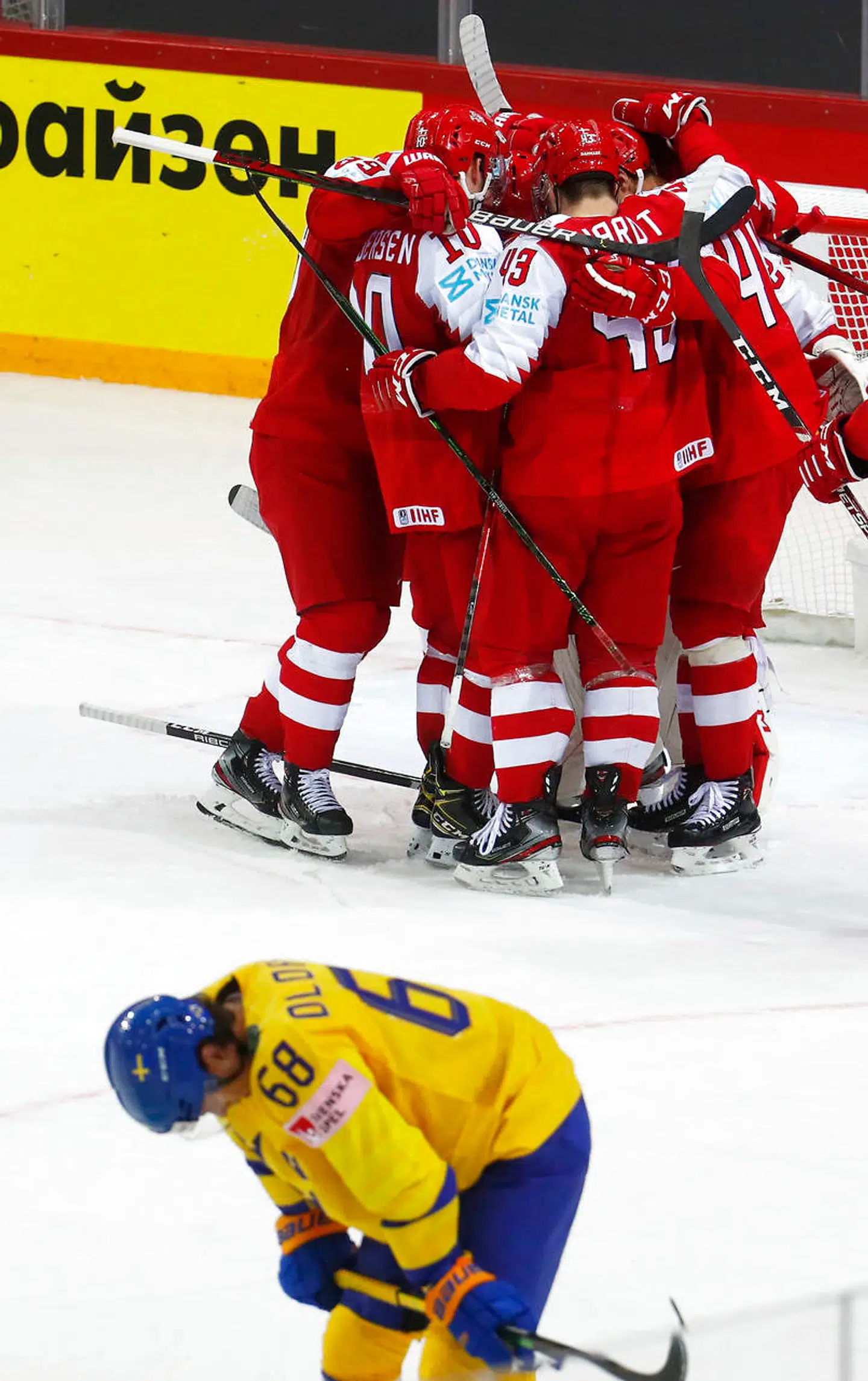 Ice Hockey - IIHF World Ice Hockey Championship 2021 - Group A - Denmark v Sweden - Olympic Sports Centre, Riga, Latvia - May 22 2021 Denmark players celebrate after the match as Sweden's Sweden looks dejected REUTERS/Ints Kalnins