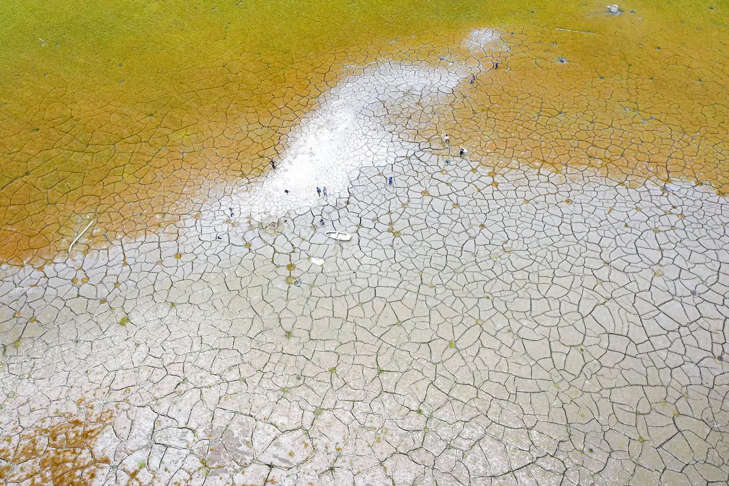 Folk står som bitte små mennesker på det, der før var under vand.