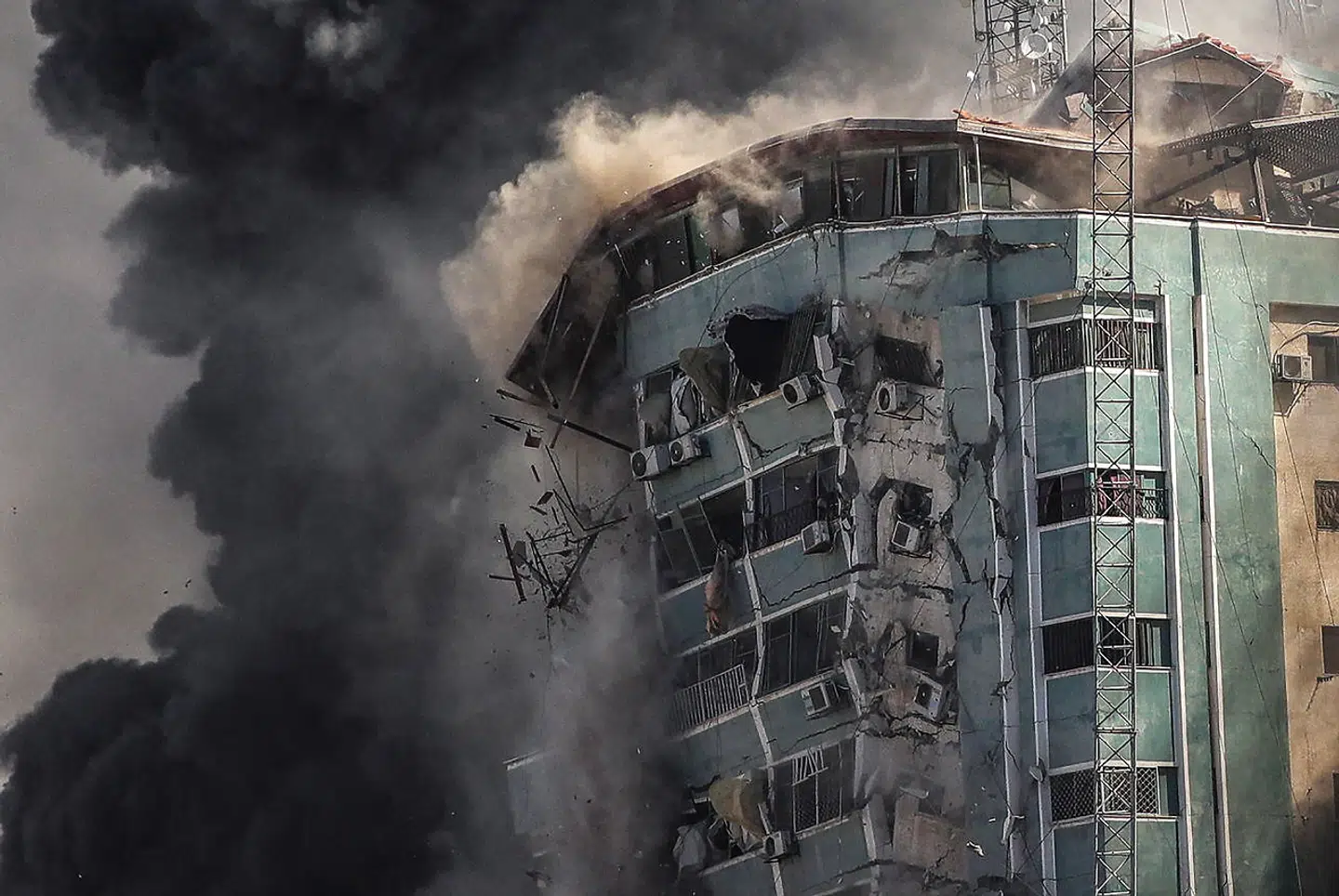 epa09201758 Smoke rises as the building collapses after an Israeli airstrike hits Al-Jalaa tower, which houses apartments and several media outlets, including The Associated Press and Al Jazeera, in Gaza City, 15 May 2021. In response to days of violent confrontations between Israeli security forces and Palestinians in Jerusalem, various Palestinian militants factions in Gaza launched rocket attacks since 10 May that killed at least nine Israelis to date. According to the Palestinian Ministry of Health, at least 139 Palestinians, including 39 children, were killed in the recent retaliatory Israeli airstrikes. EPA/MOHAMMED SABER