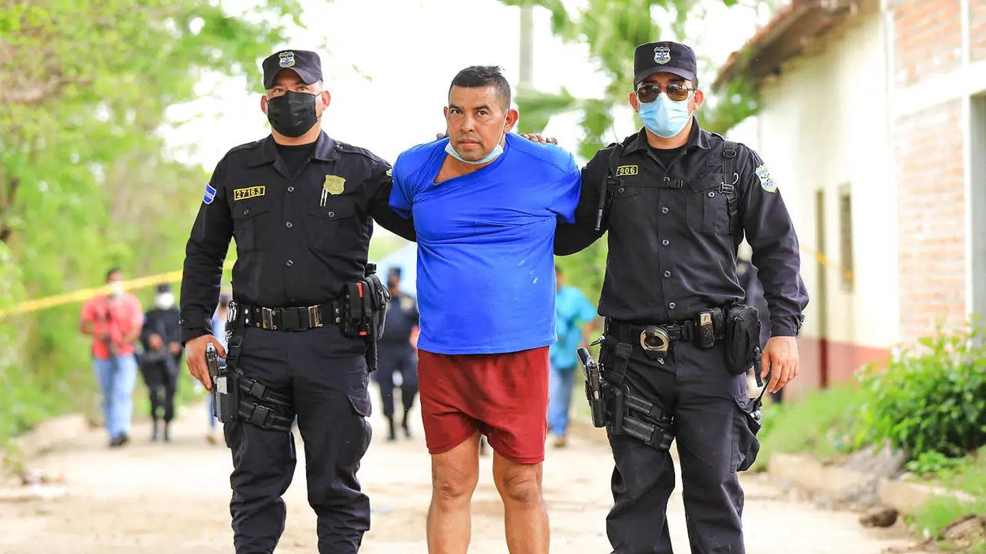 Den tidligere politimand Hugo Ernesto Osorio i politiets vartægt. (Photo by - / NATIONAL CIVIL POLICE / AFP)