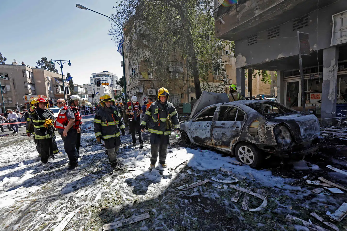 Israelsk redningsmandskab og sikkerhedsfolk ved en ødelagt bygning nær Tel Aviv. Israels militær fortsatte lørdag bølger af luftangreb mod Hamas i Gaza, mens den militante palæstinensiske bevægelse sendte nye byger af raketter ind over israelske byer - uden at der var udsigt til, at kampene ville tage af eller blive indstillet. Gil Cohen-Magen/Ritzau Scanpix
