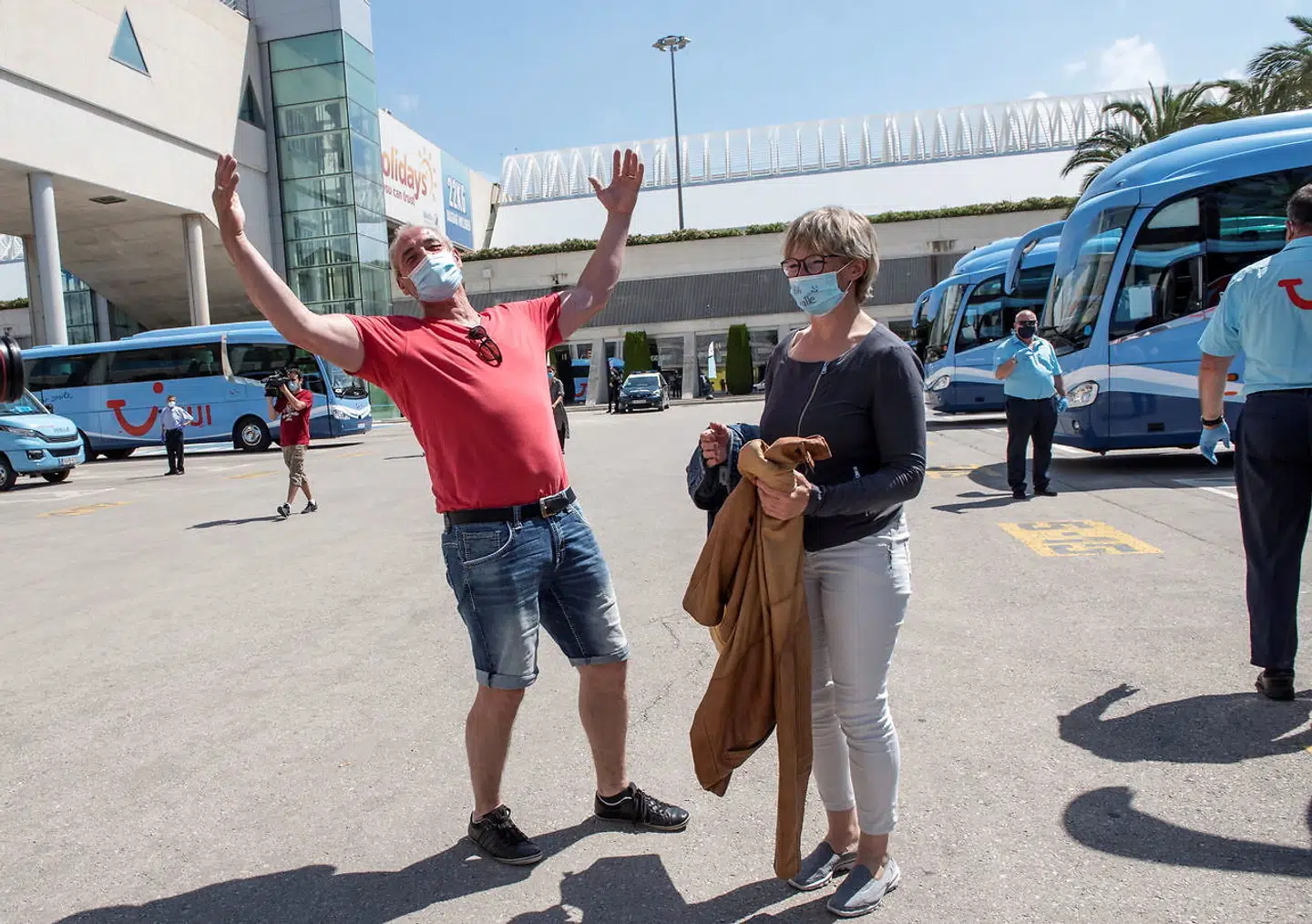De tyske turister er behørigt udstyret med ansigtsmasker, da de ankommer til hotellet i Palma på Mallorca.