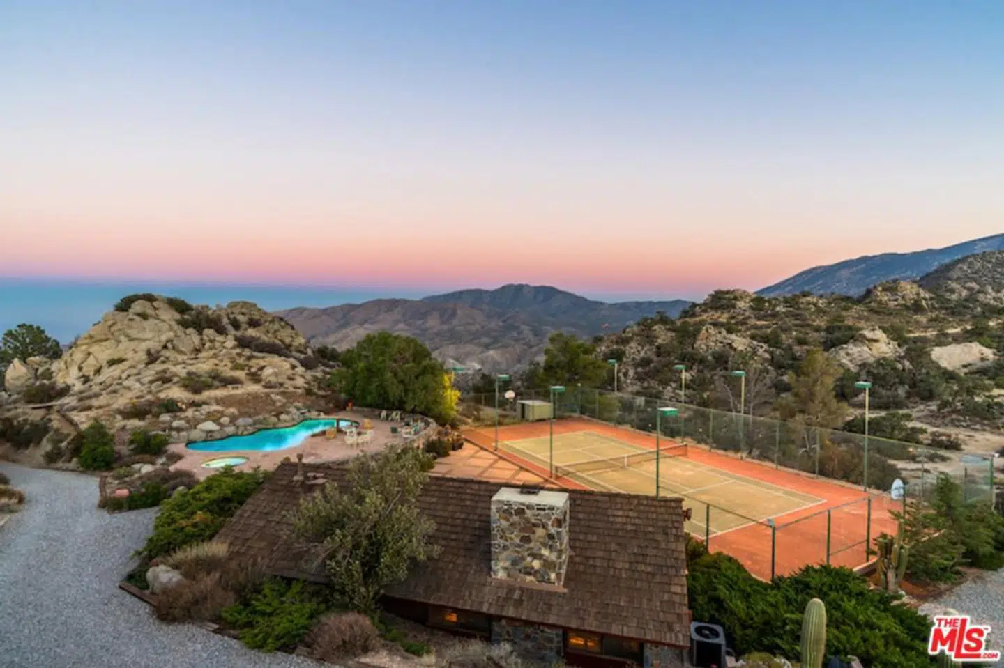 Den oplyste tennisbane gør det muligt at tage en kamp hele døgnet rundt. Foto: Realtor.com