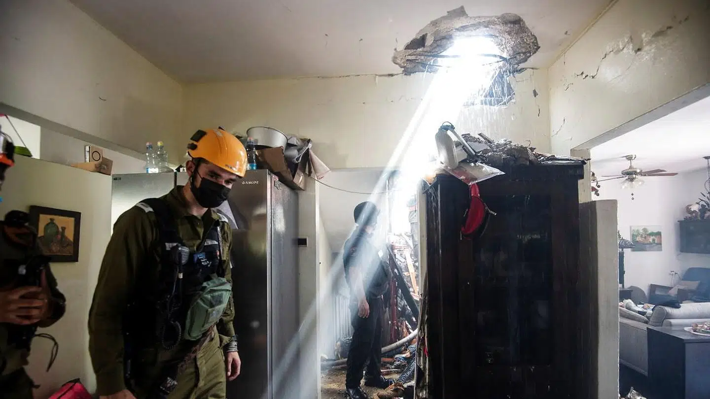 Soldater arbejder i en bygning beskadiget af en raket, der blev affyret fra Gazastriben. Billedet er fra den sydlige israelske by Ashdod den 11. maj.