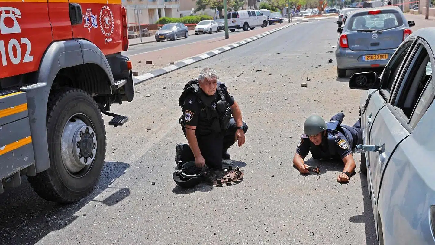 Israelske sikkerhedsstyrker søger dækning, da raketter sendt fra Gazastriben rammer i den sydlige israelske by Ashkelon. Billedet her er fra 11. maj.