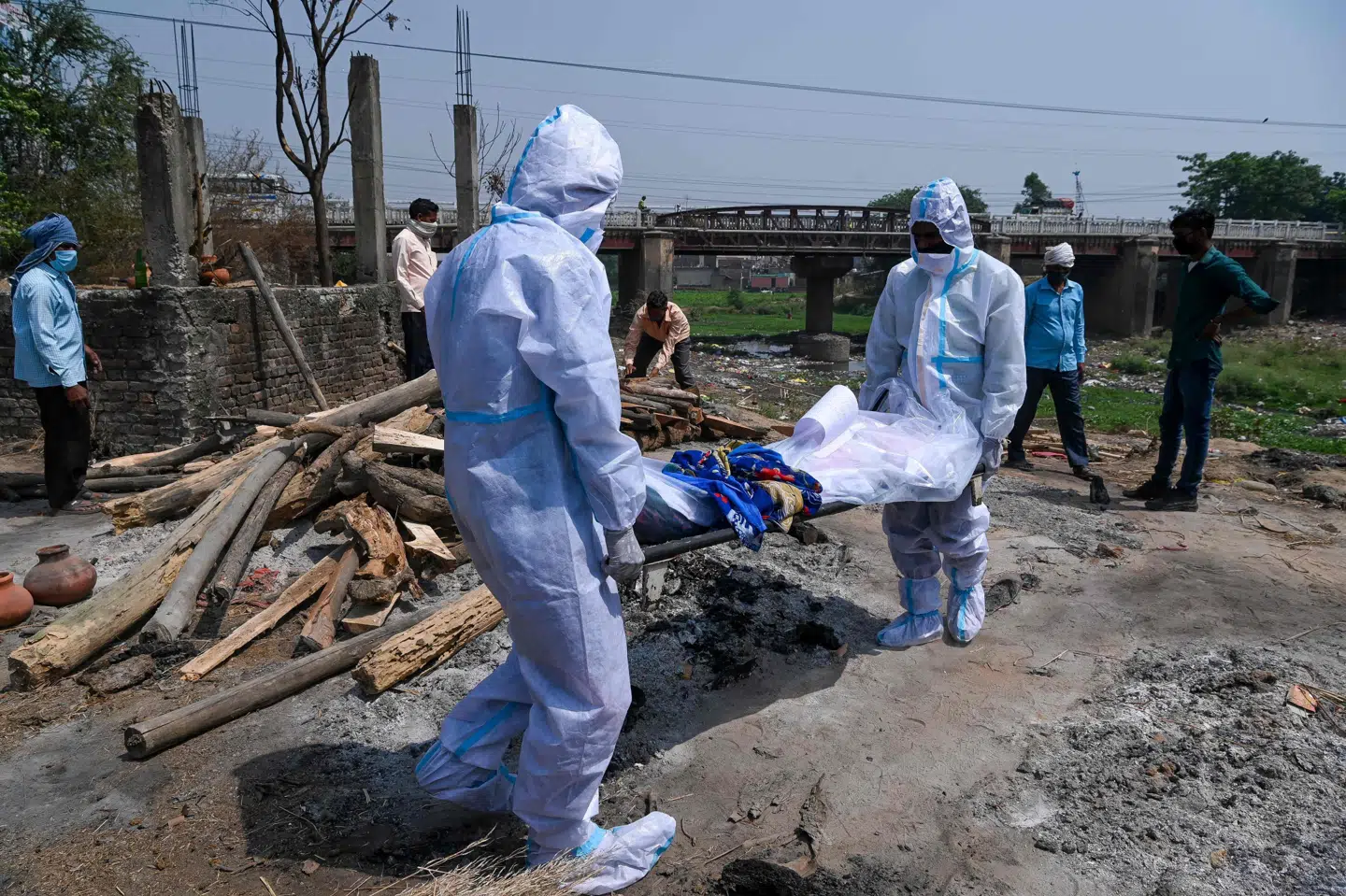 Pårørende i beskyttelsesdragter bærer denne uge en død person nær et krematorie i den indiske by Moradabad. Prakash Singh/Ritzau Scanpix