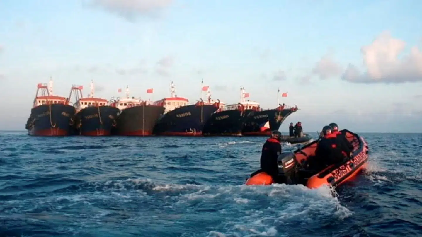 En lille både fra den filippinske kystvagt ses foran nogle af de kinesiske fartøjer.