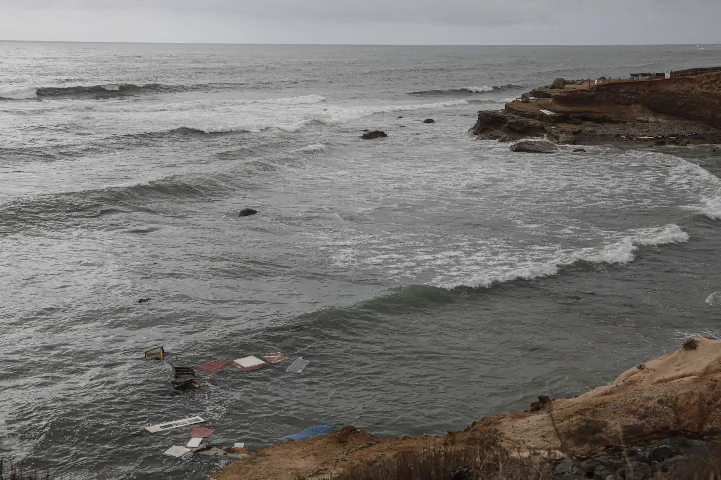 Vragrester ses her i vandet ud for San Diegos kyst søndag, efter at en formodet smuglerbåd kæntrede. Sandy Huffaker/Ritzau Scanpix