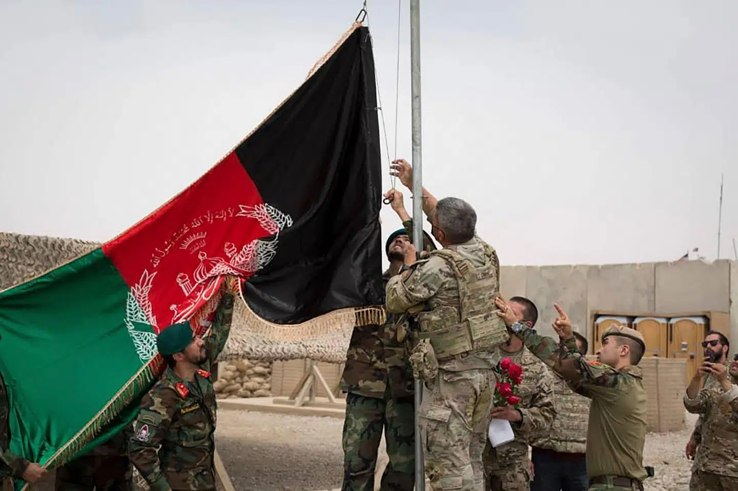 Amerikanske soldater strøg søndag deres flag, Stars and Stripes, fra flagstangen på Antonik-militærbasen i Helmand-provinsen, hvor soldater fra Afghanistans hær så kunne hejse det afghanske flag i stedet. -/Ritzau Scanpix