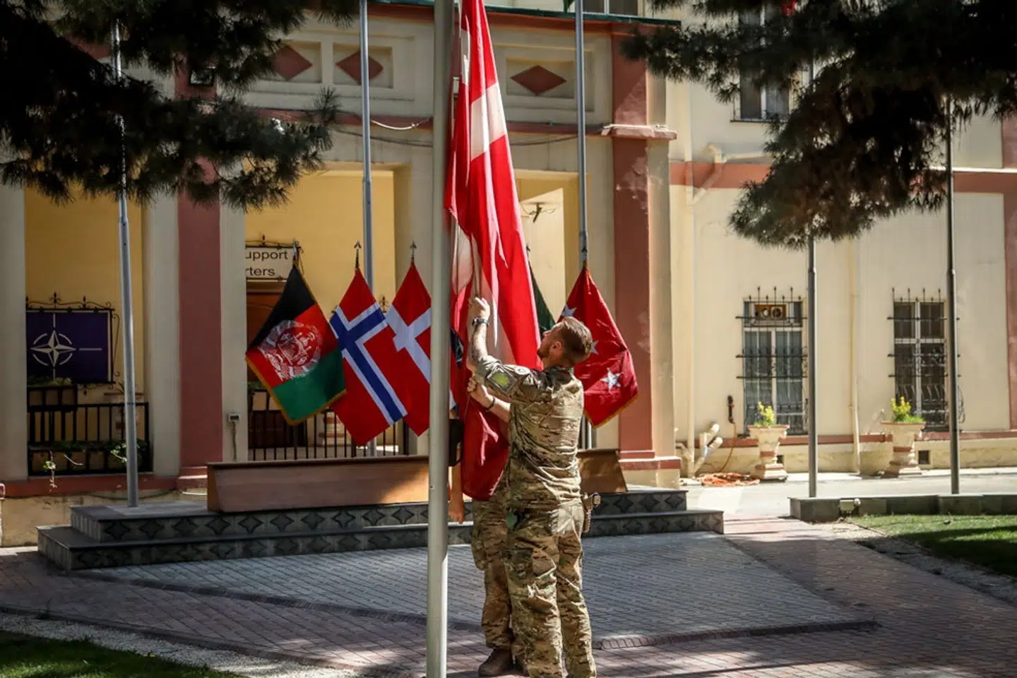 En soldat tager Dannebrog af flagstangen i hovedkvarteret for Nato-missionen i Afghanistan. Forsvaret/Free