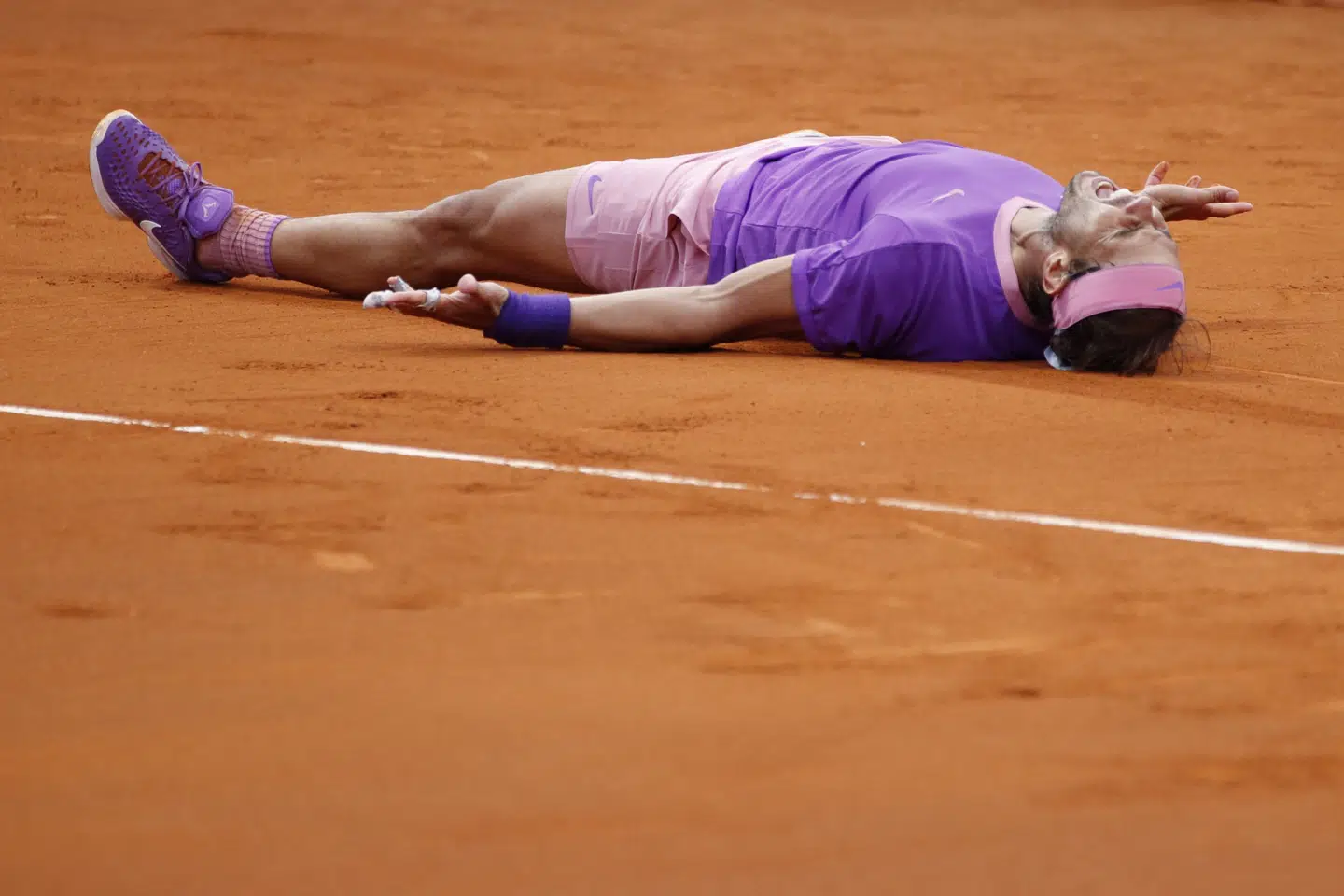 En udmattet Nadal faldt om i jubel efter sejren. Albert Gea/Reuters