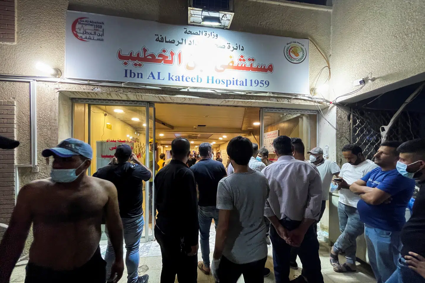 Folk har samlet sig ved hospitalsbygningen efter brand. Thaier Al-Sudani/Reuters