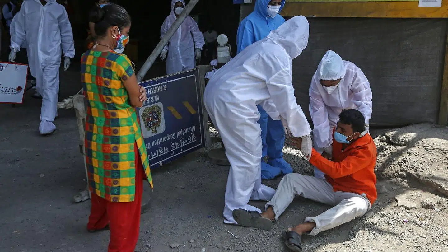 Sundhedsarbejdere tilser en coronaramt mand i Mumbai. Indien har oplevet en eksplosiv vækst i antallet af nye tilfælde.