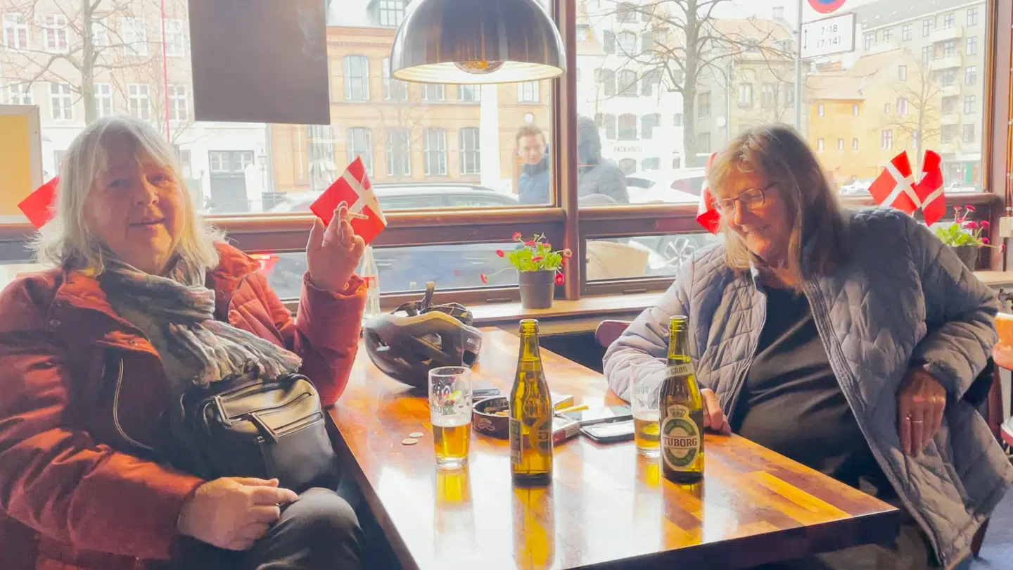 Jytte (tv) og Fymse nyder en kold øl på deres stamværtshus Kanal Bodega på Christianshavn på morgenen for den store genåbning.