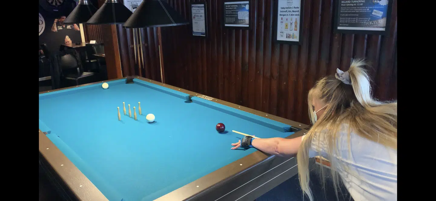 »Vi er jo som en lille familie her. Vi har et rigtig godt sammenhold, og vi har den samme humor. Vi går rigtig godt i spænd med hinanden, så det betyder meget at kunne komme herned. Det er en sindssyg god dag i dag,« siger Jeanet Rasmussen, som er stamgæst på Ørkild i Svendborg, og som bruger mange timer ved billardbordet.Foto: Jens Anton Havskov