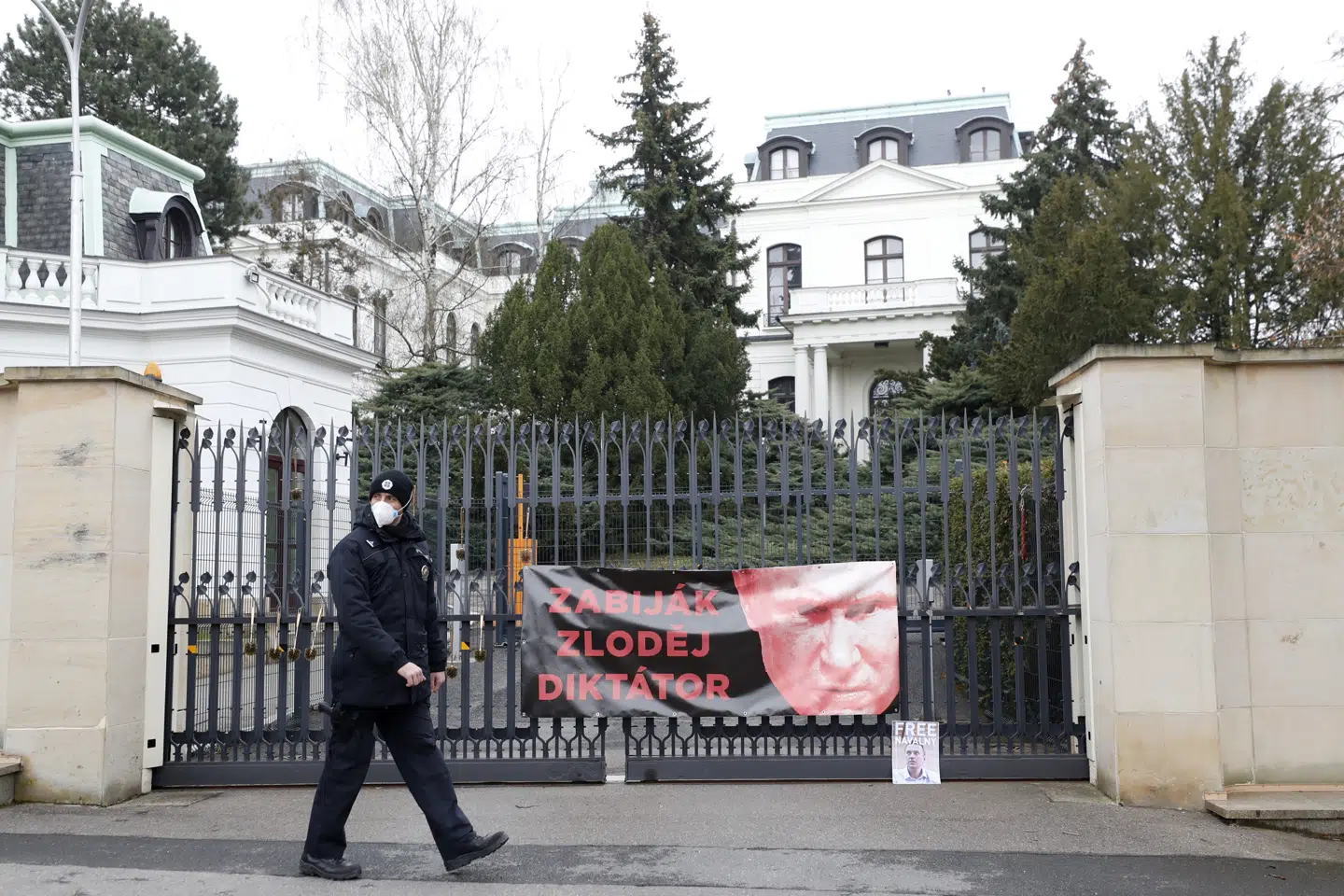 En politimand går forbi lågen ind til den russiske ambassade i Prag, hvor demonstranter fredag havde hængt en plakat op med et billede af Ruslands præsident, Vladimir Putin, med teksten: Morder, tyv, diktator. Petr David Josek/Ritzau Scanpix
