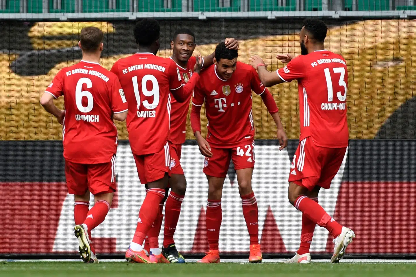Jamal Musiala (nummer to fra højre) bliver omringet af holdkammeraterne fra Bayern München, efter at det 18-årige tyske stortalent har scoret sit andet mål i 3-2-sejren over Wolfsburg. Fabian Bimmer/Ritzau Scanpix