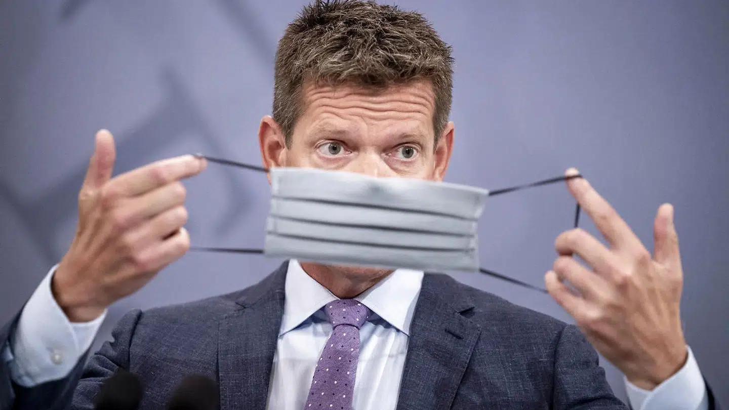 Sundhedsstyrelsens direktør Søren Brostrøm demonstrerer hvordan, man tager mundbind på.