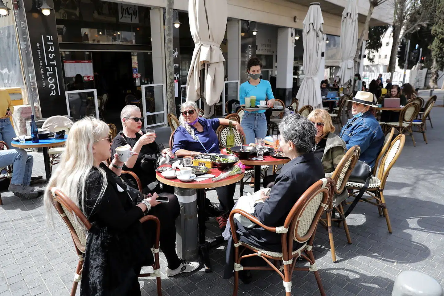 Israelerne kan igen samles på restauranter, cafeer og barer i takt med, at smittetallene er raslet ned. EPA/ABIR SULTAN