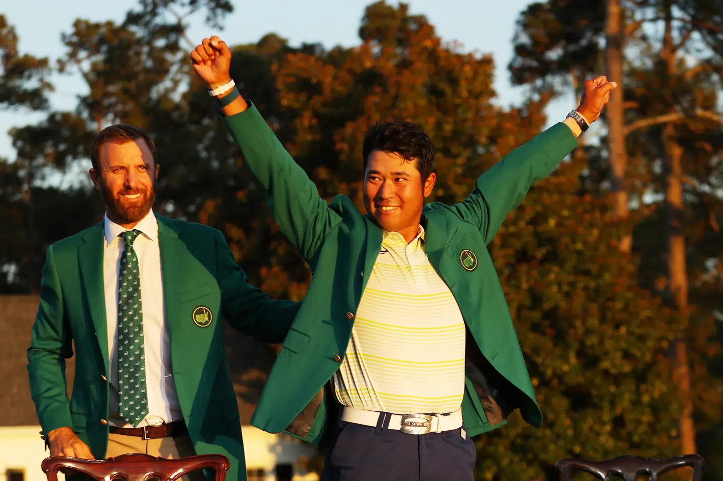 Japanske Hideki Matsuyama fejrer sin US Masters-sejr efter at have fået den ikoniske grønne jakke på af sidste års vinder, amerikanske Dustin Johnson. Kevin C. Cox/Ritzau Scanpix