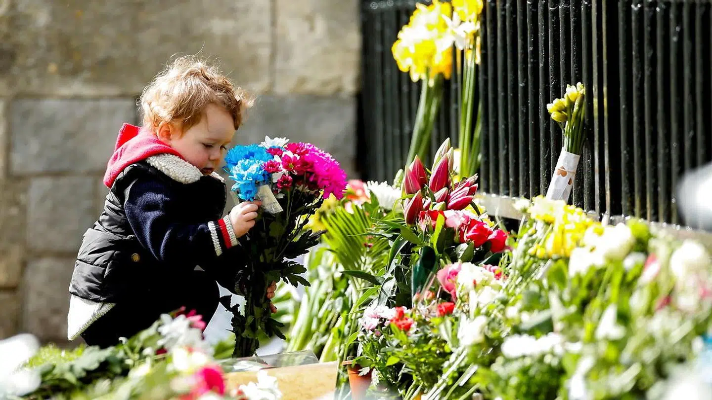 Windsor nær London: Et barn holder en buket blomster foran Windsor Castle.