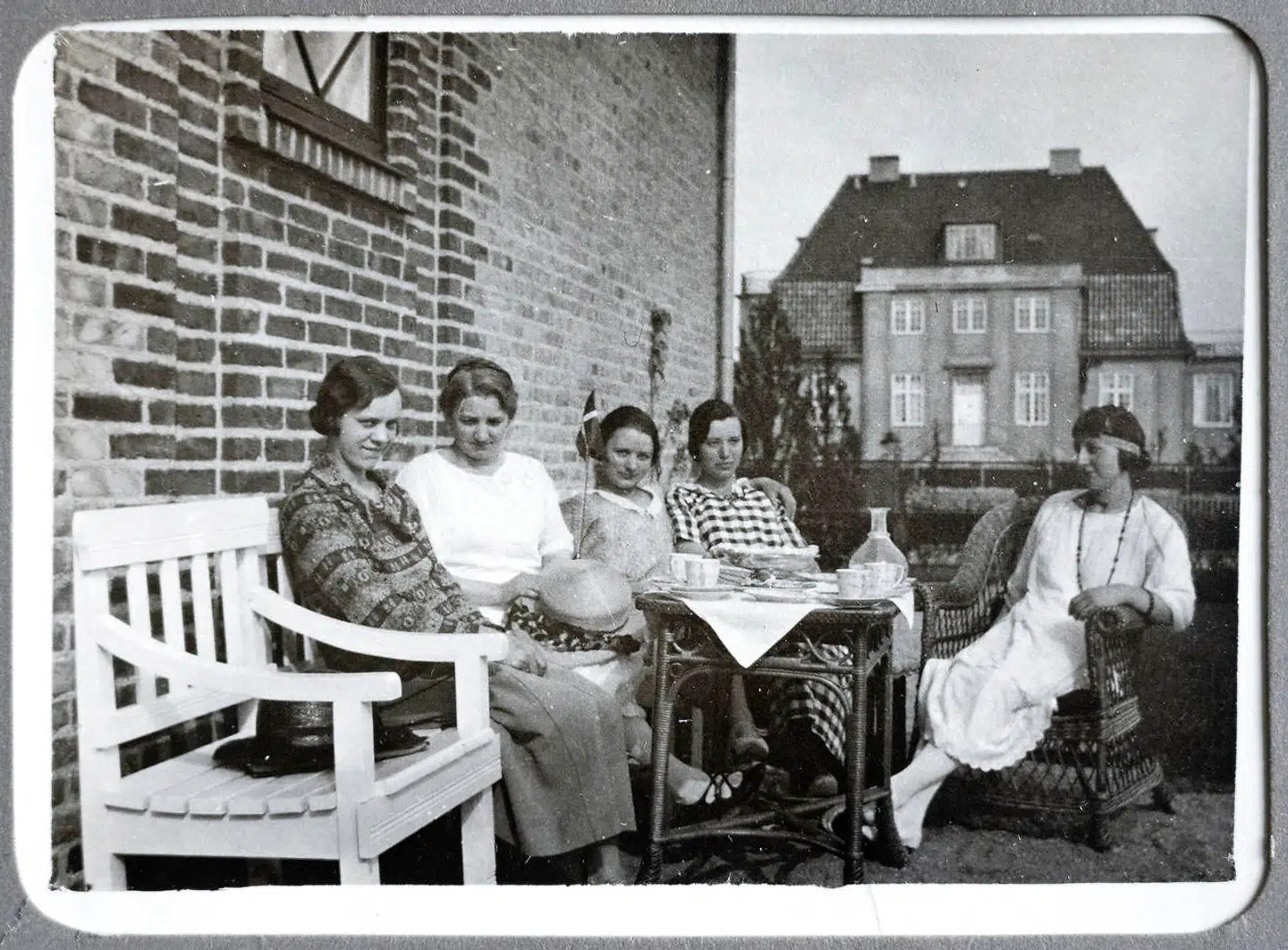 Her ses Det Hvide Hus på et privatfoto fra 1924. Kvinderne i familien overfor drikker te, og i baggrunden ses Det Hvide Hus, som dengang var gult.