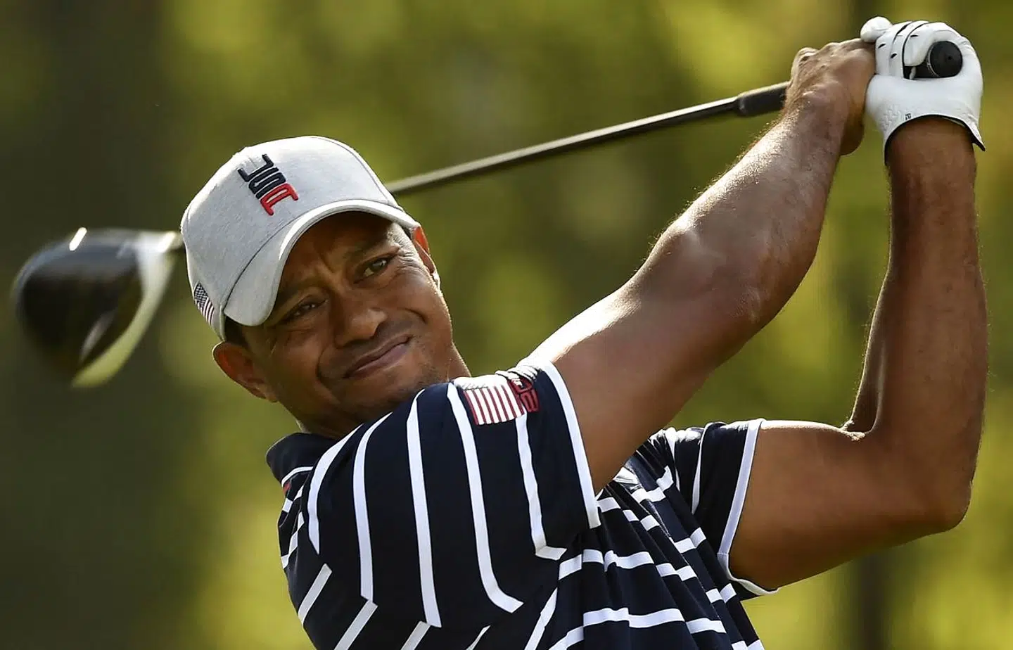 (FILES) In this file photo US golfer Tiger Woods plays a tee shot during his fourball match on the first day of the 42nd Ryder Cup at Le Golf National Course at Saint-Quentin-en-Yvelines, south-west of Paris on September 28, 2018. - Tiger Woods, a 15-time major champion recovering from injuries suffered last month in a car crash, is making a comeback in golfing videogames, announcing a new deal on March 16, 2021 with 2K. The company and Woods have agreed upon a long-term exclusive partnership and 2K announced it has struck a deal to obtain HB Studios, developers of the PGA Tour 2K21 as well as The Golf Club franchise. (Photo by Eric Feferberg / AFP)