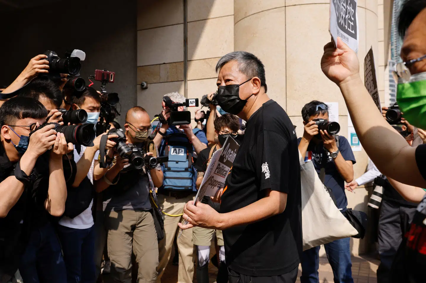 Forud for torsdagens retssag havde en gruppe af tilhængere og mindst en af de tiltalte samlet sig foran retsbygningen for at vise deres utilfredshed med myndighederne. Tyrone Siu/Reuters