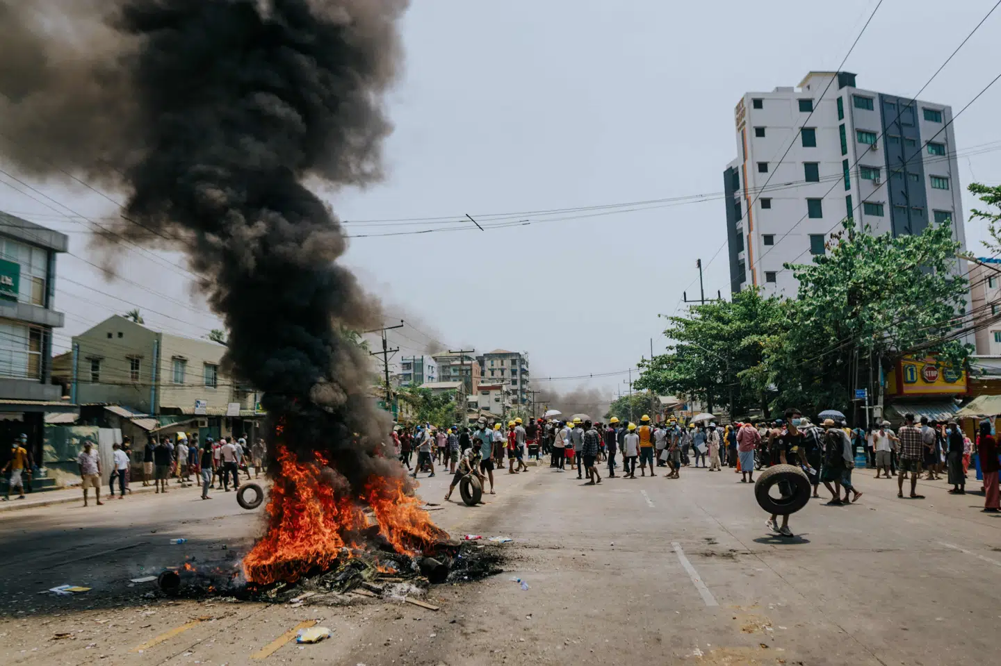 Demonstranter har onsdag sat ild til en affaldsbunke på gaden i Myanmars største by, Yangon, hvor indbyggerne i mange kvarterer har bygget barrikader i håb om at holde militæret på afstand. Handout/Ritzau Scanpix