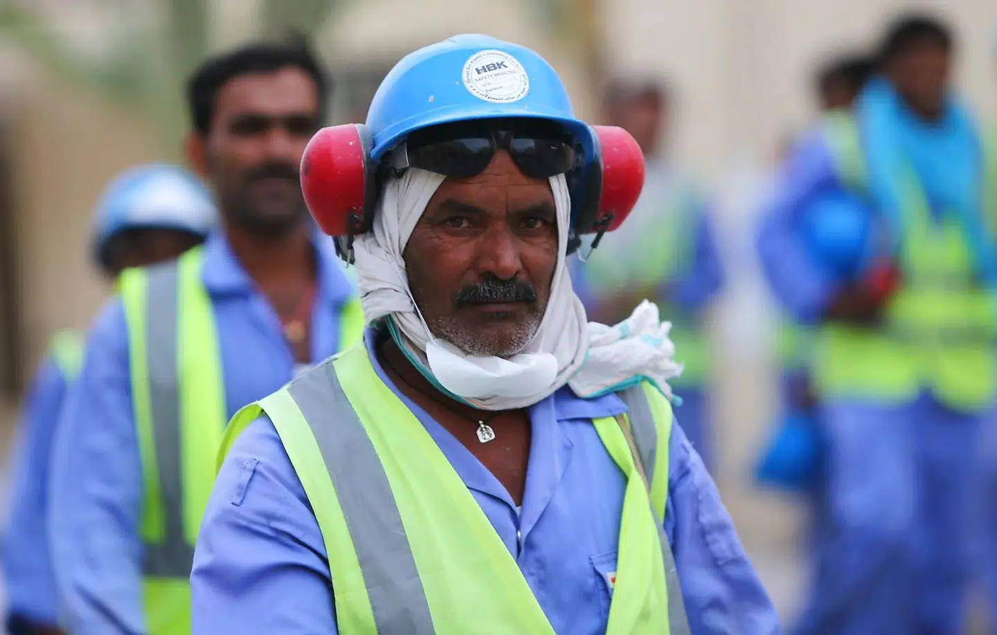 Foreign laborers working on the construction site of the al-Wakrah football stadium, one of the Qatar's 2022 World Cup stadiums, walk back to their accomodation at the Ezdan 40 compound after finishing work on May 4, 2015, in Doha's Al-Wakrah southern suburbs. The Qatari government has announced new projects to provide better accommodation for up to one million migrant workers. Today they organised a media tour of existing housing camps and new ones. AFP PHOTO / MARWAN NAAMANI