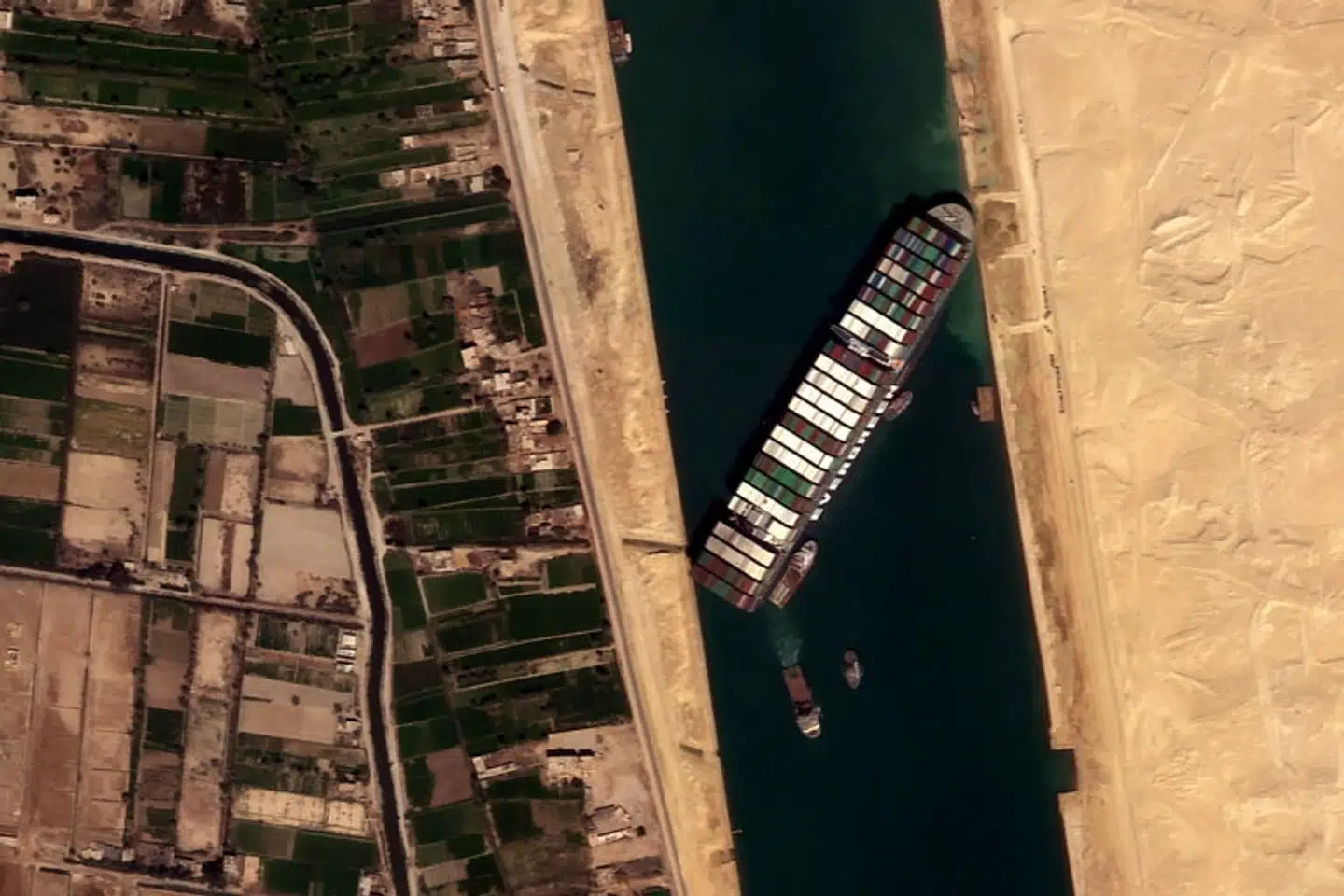 Det 400 meter lange og 59 meter brede containerskib Ever Given stødte på grund i Suez-kanalen tirsdag, og det kan tage flere uger, inden det er fri. Satellogic/Reuters
