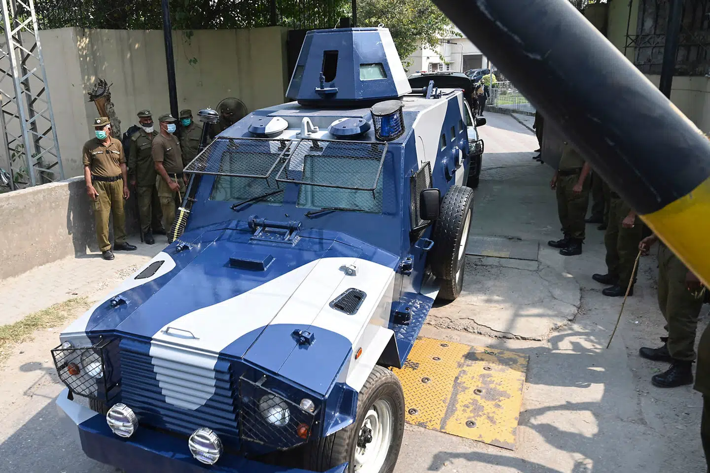 Politimænd står på vagt, mens en bil med en af de anklagede forlader retten i Lahore, Pakistan.