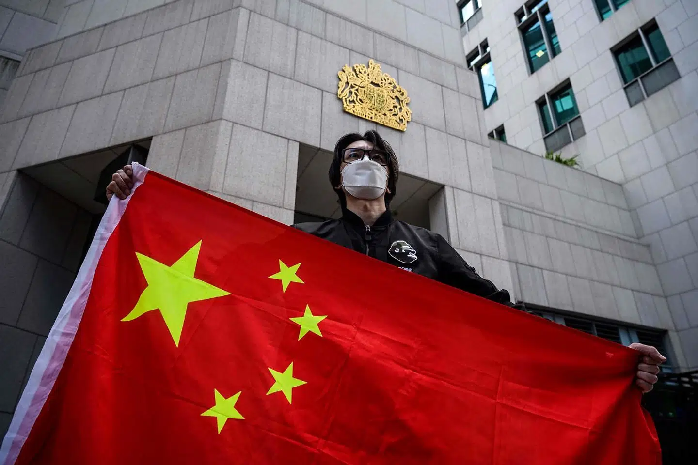 En mand holder det kinesiske flag under en protest uden for det britiske konsulat 1. februar 2021.