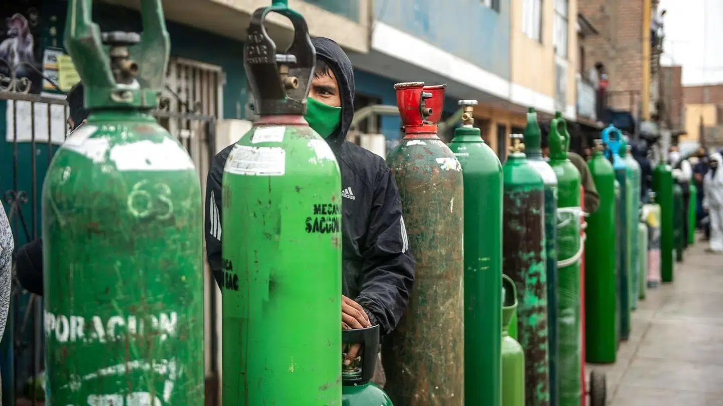 Folk står i kø for at få fyldt ilt på flakser, der bruges til at hjælpe covid-19 patienter. Ilten, må folk selv betale for, da sundhedssystemerne er ved at bukke under flere steder.