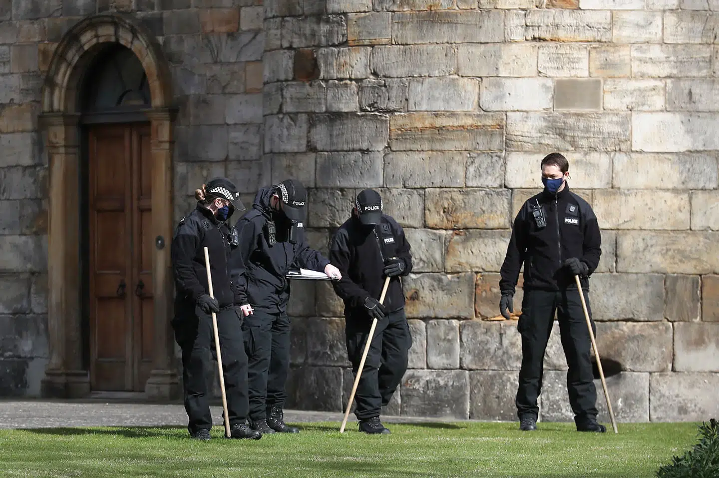 Politiet undersøger græs og krat omkring slottet.