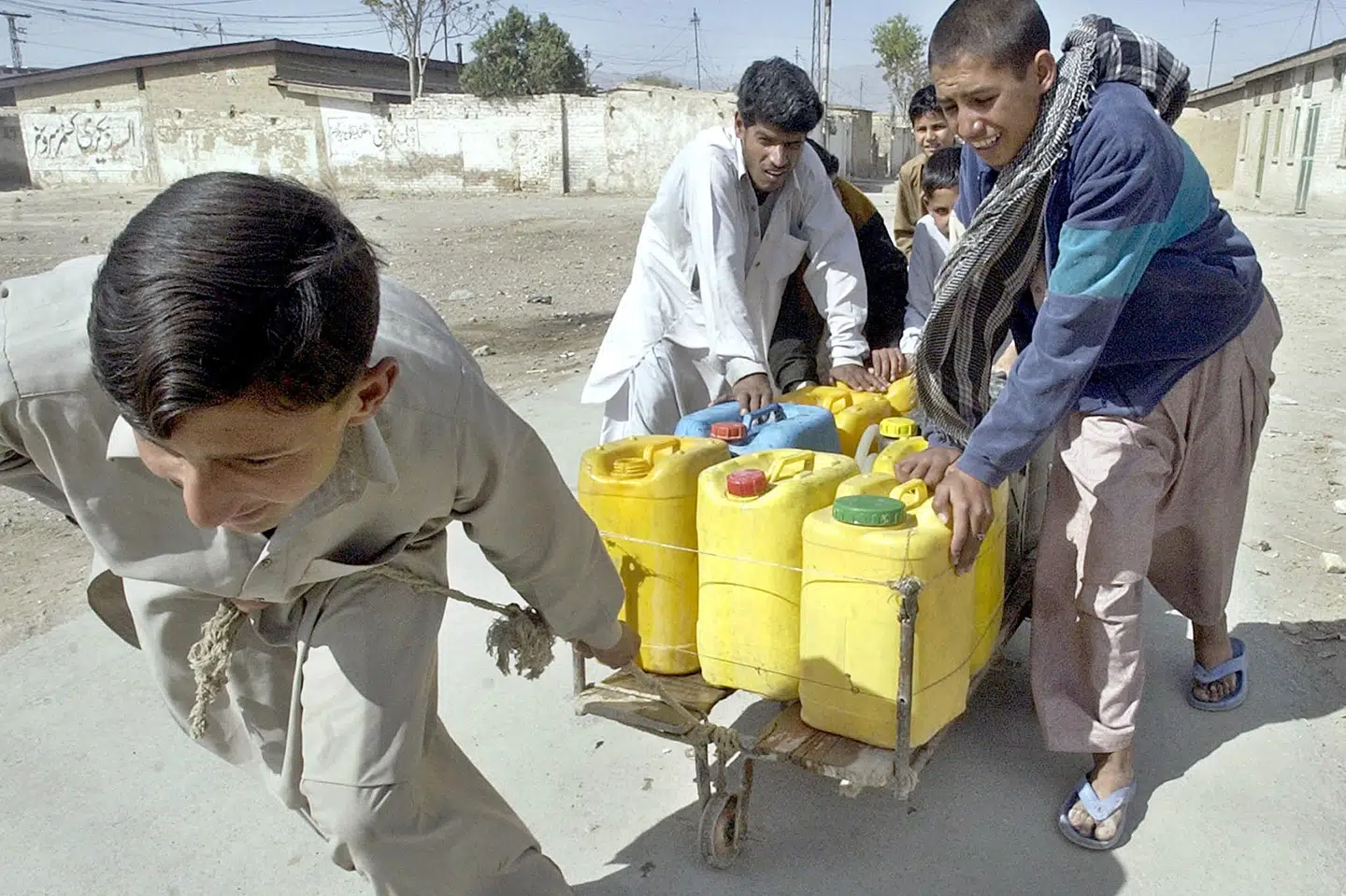 Unge pakistanere på vej hjem med drikkedunke i Quetta. FN siger i ny rapport, at der alt for ofte ikke bliver taget hensyn til værdien af vand eller til alle de følgeværdier, der er knyttet til vand. (Arkivfoto) Banaras Khan/Ritzau Scanpix