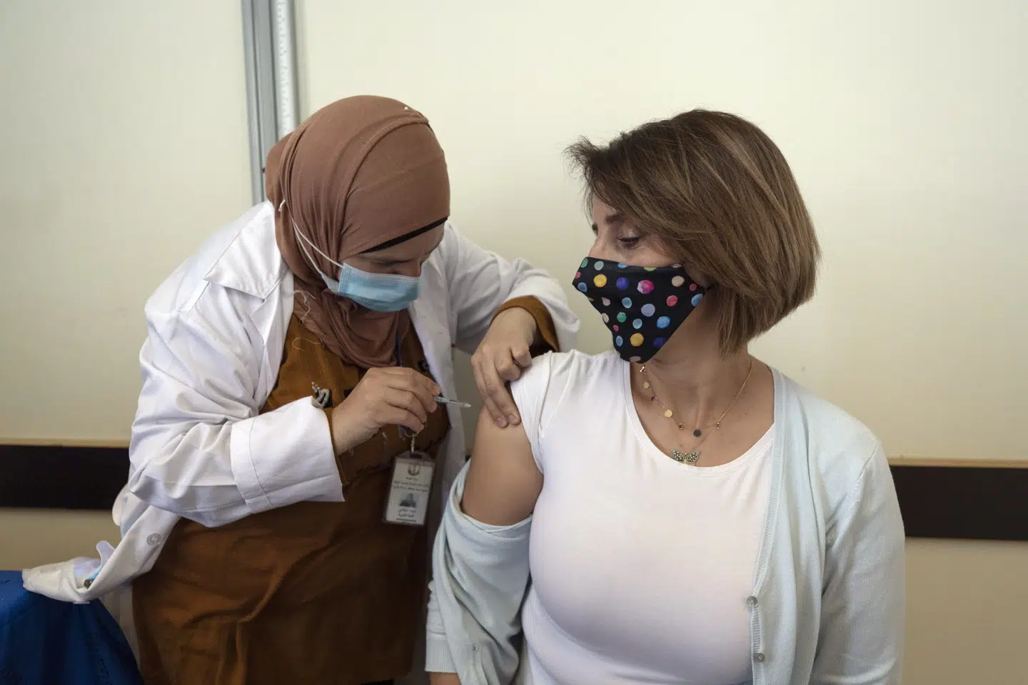 En palæstinensisk læge modtager i Ramallah på Vestbredden sit første stik af en en vaccine mod covid-19. Søndag gik udrulningen af vaccinerne i gang på Vestbredden, efter de palæstinensiske myndigheder har modtaget de første 60.000 doser fra FN's fordelingssystem Covax. Nasser Nasser/Ritzau Scanpix