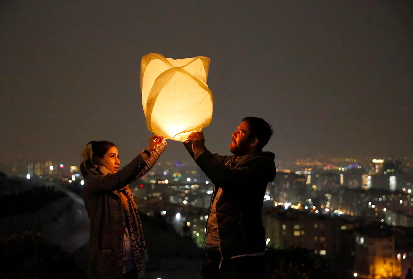 De er ved at slippe en lanterne væk på en bakketop i Teheran.