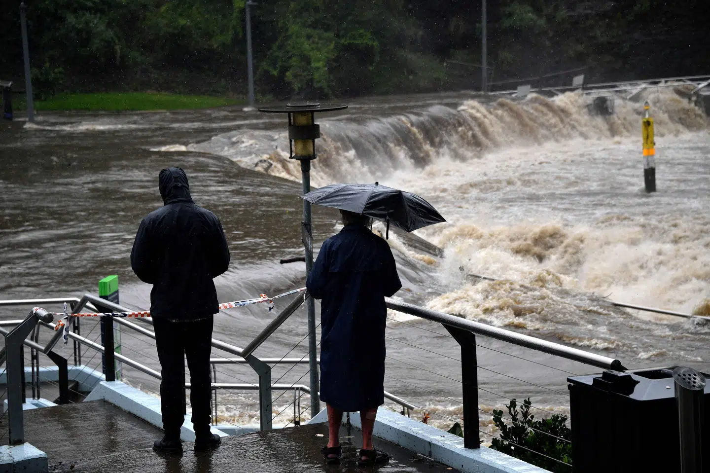 Lokale ser på, mens Parramatta-floden i Sydney går over sine bredder lørdag. Saeed Khan/Ritzau Scanpix